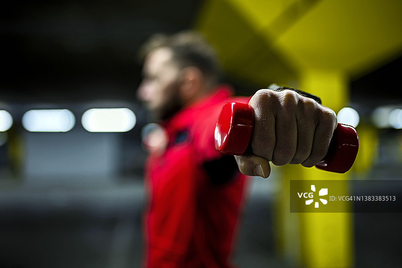 用哑铃锻炼的年轻男人，专注于重量图片素材