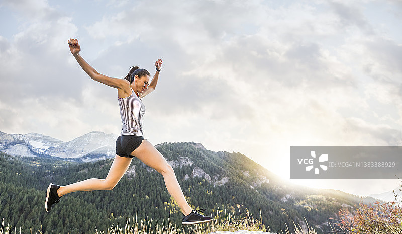 美国犹他州，美国福克，女子在日落时于山地景观中慢跑图片素材