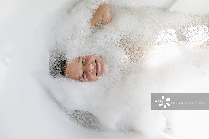在泡泡浴中的男孩（8-9岁）图片素材