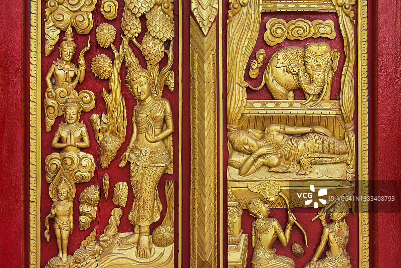 泰国黎逸府佛教寺庙红门上的金色雕刻图片素材