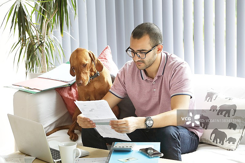 男人和狗一起做家庭账务图片素材