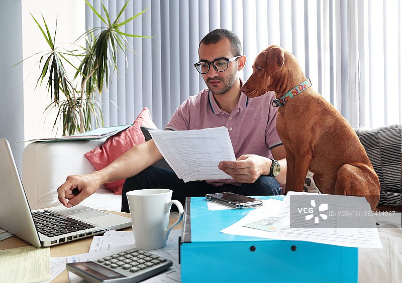 男人和狗一起做家庭账务图片素材