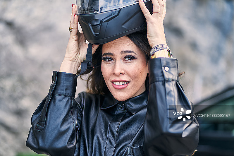 戴头盔的自信西班牙裔女摩托车手图片素材