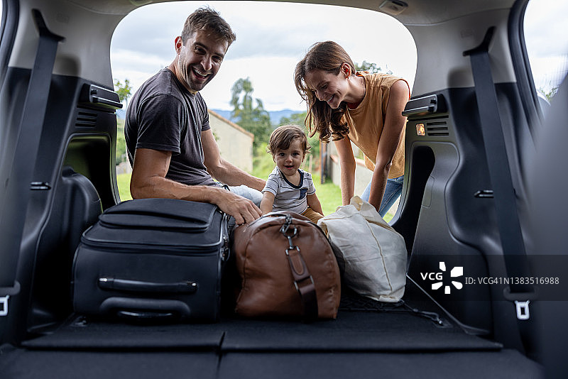 幸福家庭自驾游，将行李放入后备箱图片素材