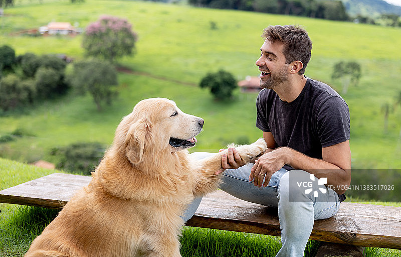 快乐的男人在户外训练他的狗图片素材