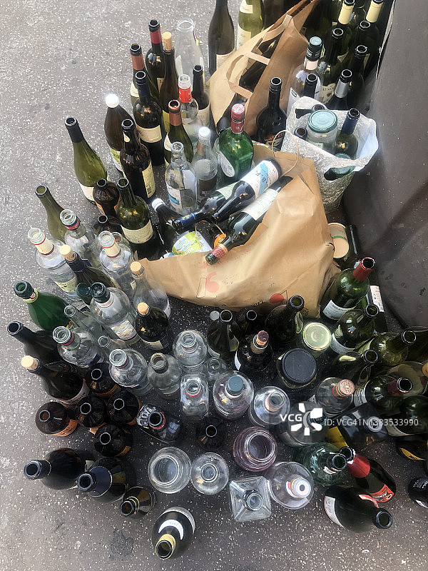 巴黎街道上回收箱旁边的瓶子图片素材