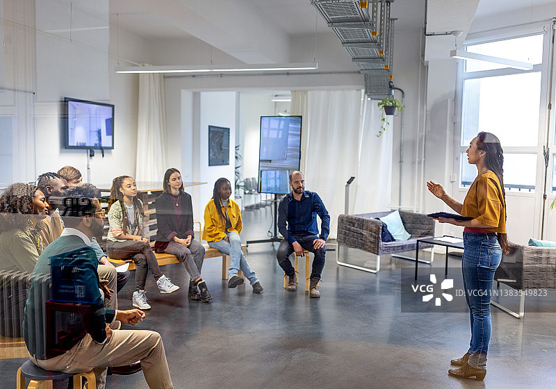 年轻亚洲商务女士在会议中与同事交谈图片素材