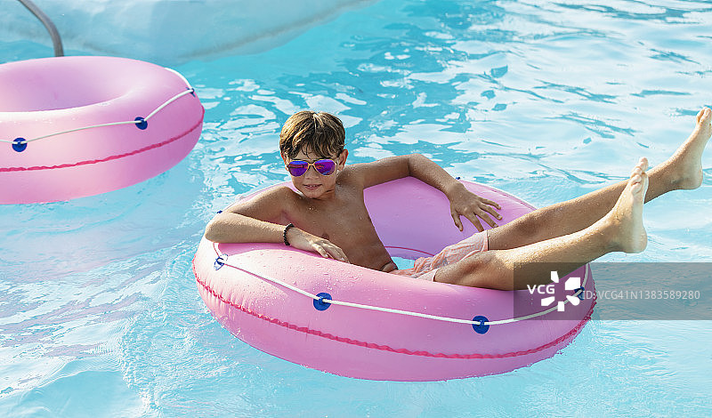 男孩在水上乐园漂流河上漂浮图片素材