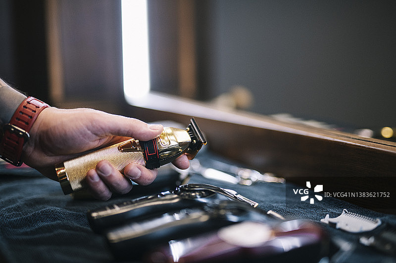 理发师从工作台拿起推剪图片素材