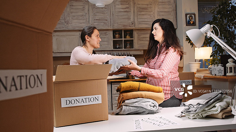 准备捐赠箱的孕妇。慈善。图片素材