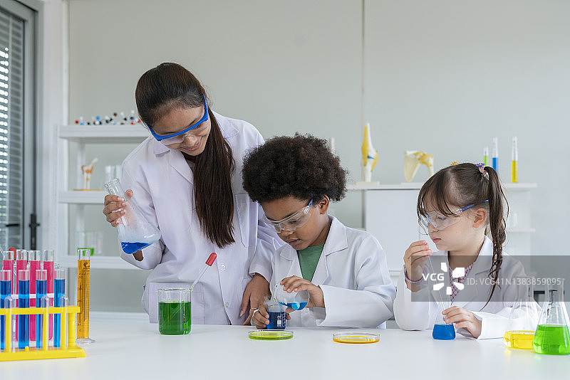 可爱的小朋友们在实验室里用滴管兴奋地检查彩色化学物质图片素材