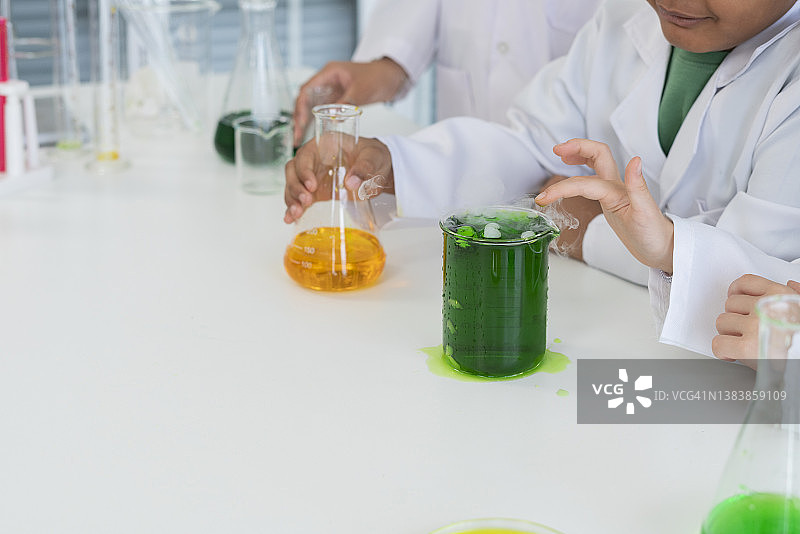 可爱的小朋友们在实验室里用滴管兴奋地检查彩色化学物质图片素材