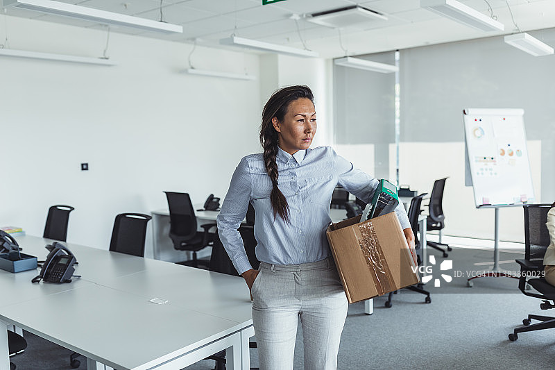 失业的亚洲中年妇女拿着纸箱离开办公室图片素材