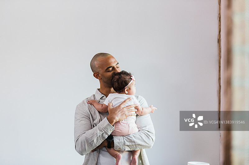 单亲父亲温柔地亲吻宝宝的头图片素材