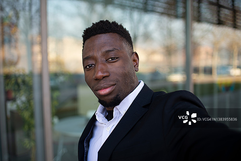 自信的黑人经理在玻璃墙附近自拍图片素材