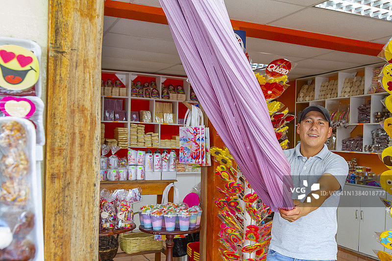 一个快乐的男人正在制作“melcochas”，这是来自厄瓜多尔巴尼奥斯的传统糖果图片素材