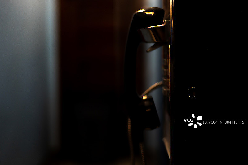 学校建筑内老式公用付费电话的侧面图图片素材