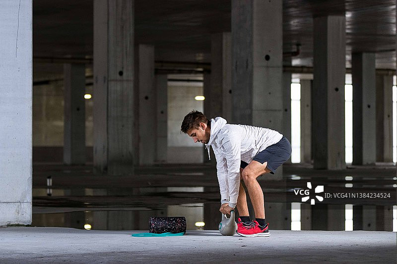 做壶铃运动的白人男运动员图片素材