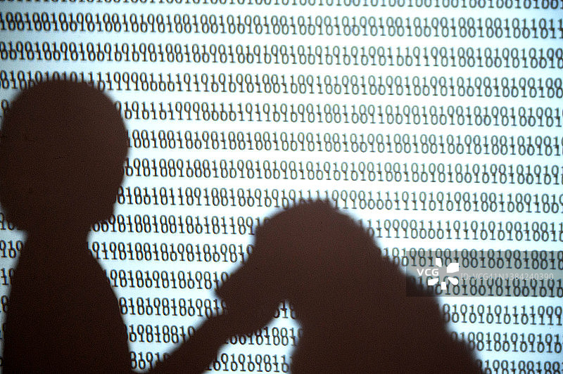 一个人用代码喂养狗形机器人的影子图片素材