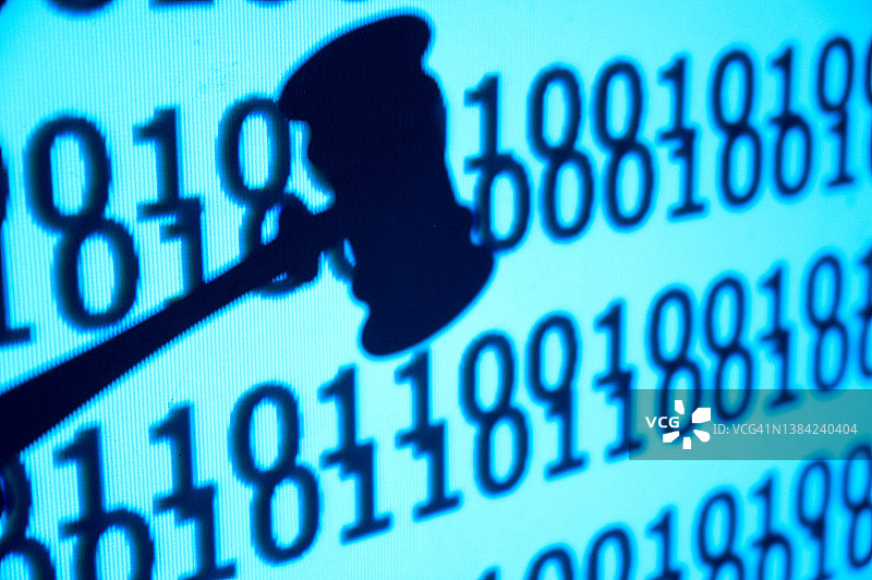 正义概念：法官的木槌判决特写，背景为二进制代码图片素材