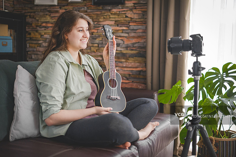 女子通过网络视频教程进行吉他教学图片素材