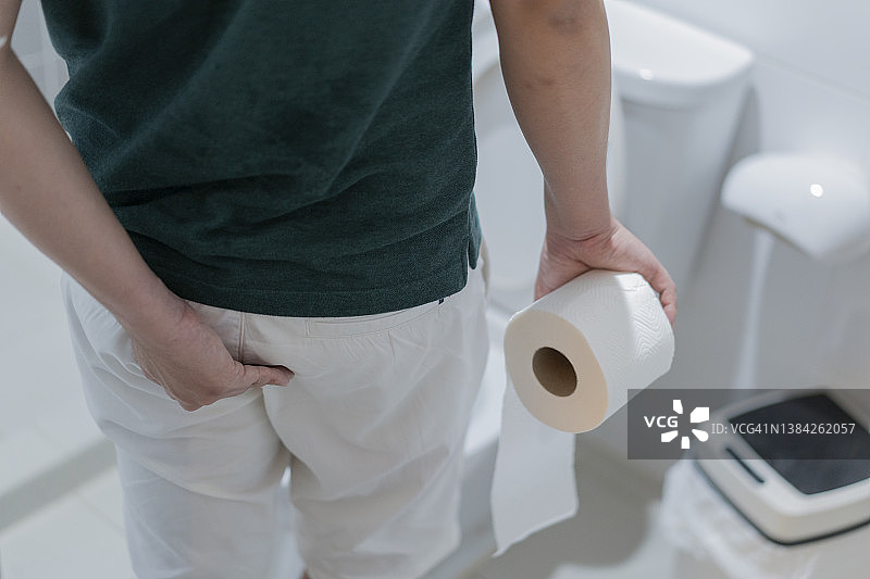 男人在浴室里拿着卷筒卫生纸图片素材