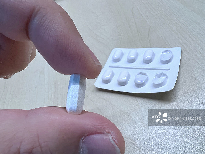 成年人的手拿着止痛药片图片素材