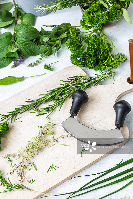 月亮刀与砧板上各式新鲜香草图片素材