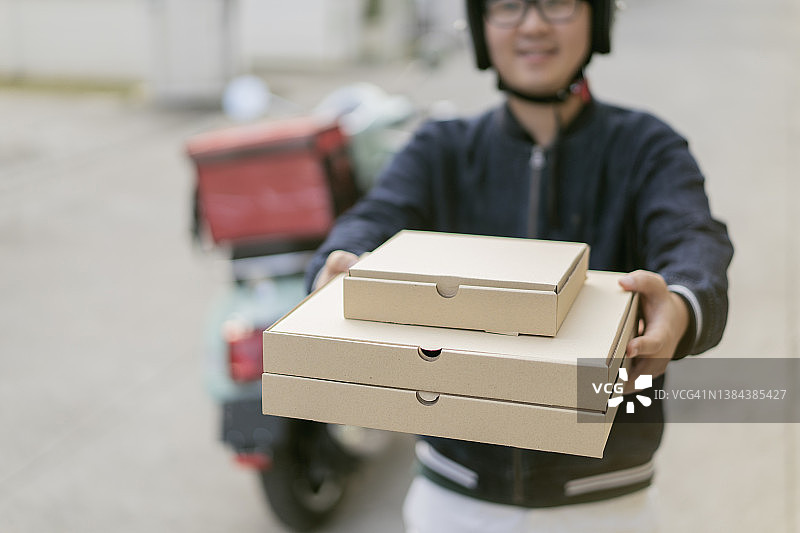 送货员拿着披萨盒和摩托车图片素材