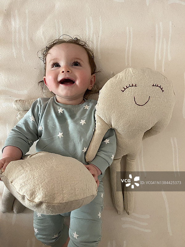 笑容灿烂的宝贝拿着手工棉布娃娃图片素材