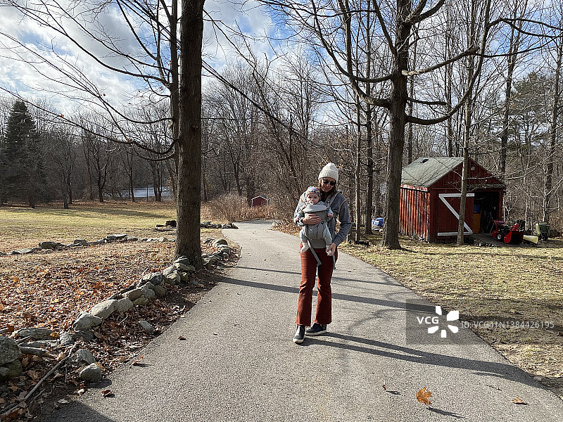 母亲在乡村地区用婴儿背带带着宝宝图片素材