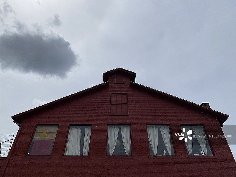 老房子的顶层，有四扇窗户，其中一扇用木板封住图片素材