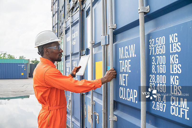 工程师们正在监督仓库内装有集装箱的货物的运输。集装箱在进出口业务和物流中图片素材