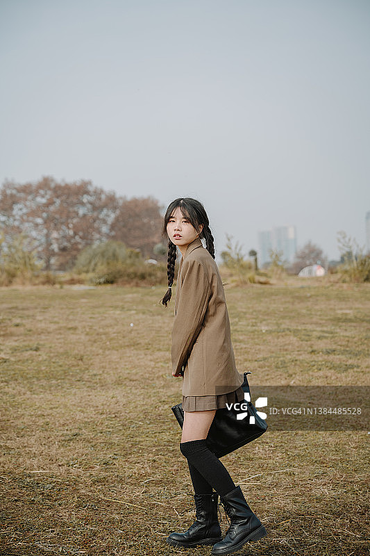 在草地上快乐奔跑的亚洲女孩图片素材