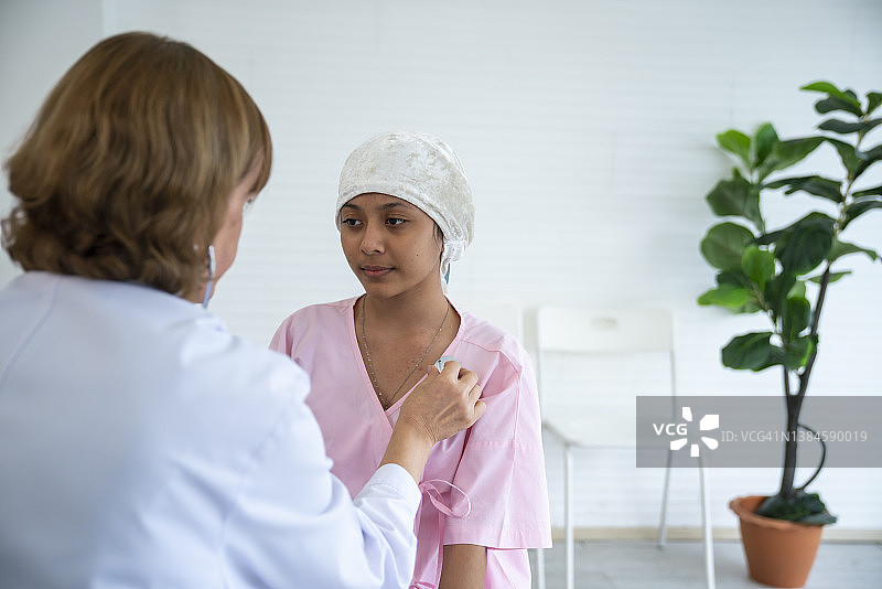 戴着听诊器的医生与患癌症的孩子交谈图片素材