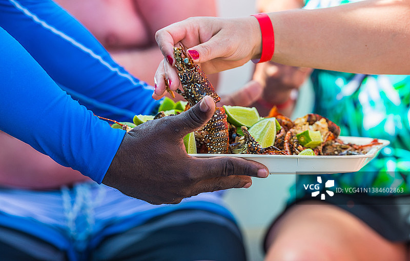 女游客品尝烤龙虾图片素材