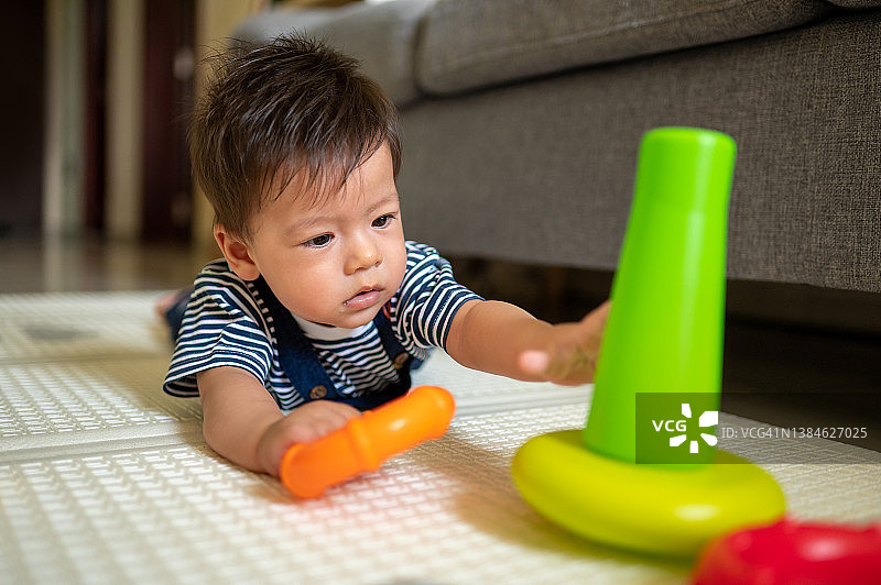 在客厅婴儿安全软垫上玩耍的男婴图片素材