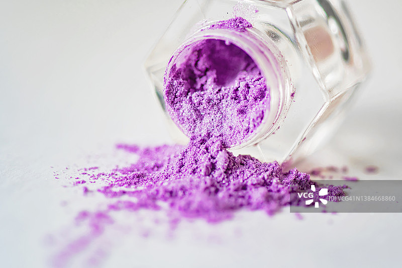 白色背景上透明容器中溢出的粉末眼影图片素材