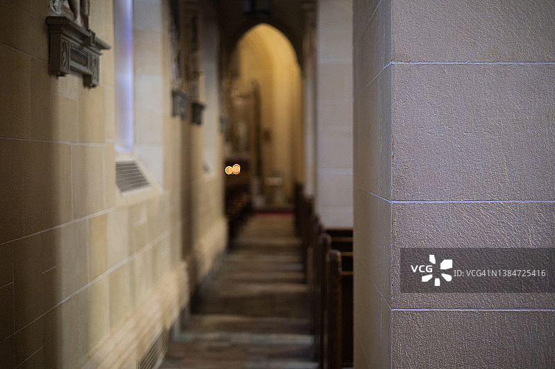 教堂侧通道走廊，远处可见传统祈祷蜡烛图片素材