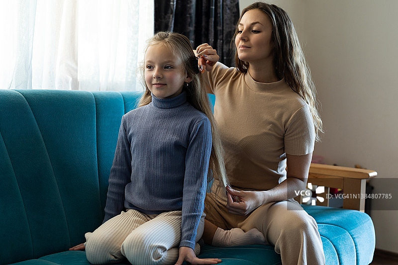 妈妈在家给女儿梳头发图片素材