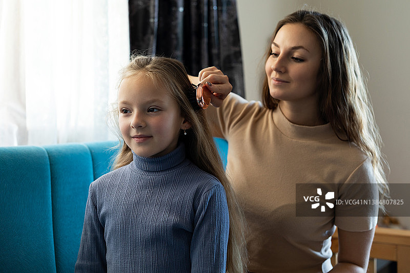 妈妈在家给女儿梳头发图片素材