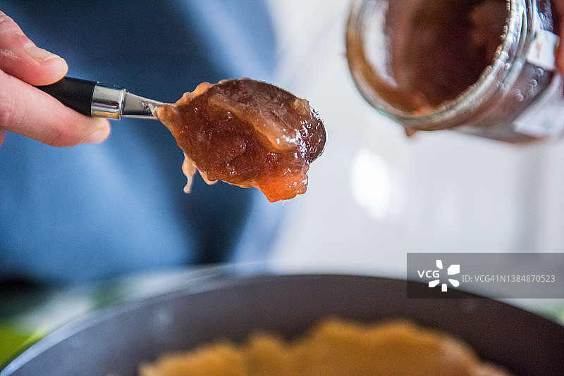 一勺蜜饯淋在蛋糕面团上图片素材