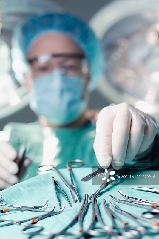 外科医生在手术中伸手拿手术刀片图片素材