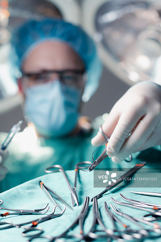 外科医生在手术中取针持器和缝合线图片素材