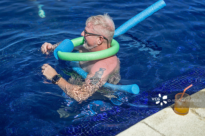 男人用泳池浮条套在脖子和身上游泳图片素材