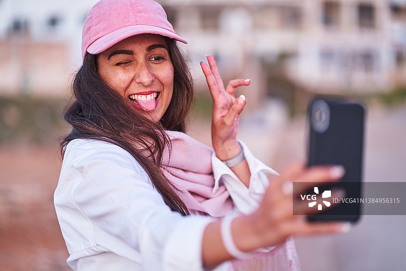 日落时分自拍的顽皮黑发女人图片素材