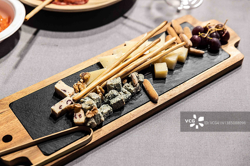 搭配葡萄、不同类型成熟奶酪、蓝纹奶酪和曼彻格奶酪的奶酪板图片素材