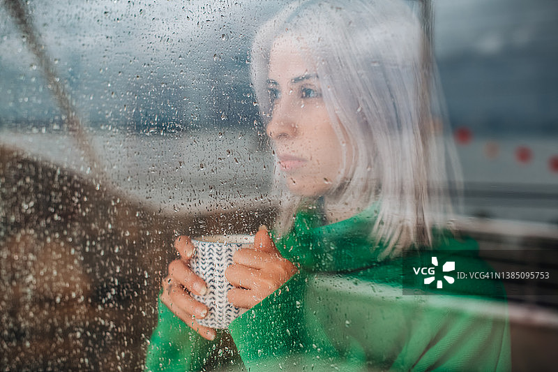 沮丧的女人隔着窗户看雨图片素材