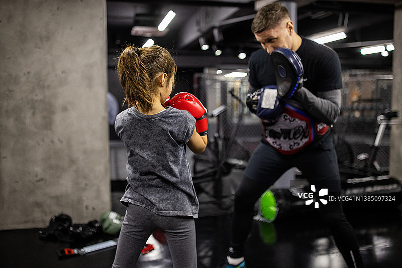 女拳击手在男教练的指导下进行拳击训练图片素材
