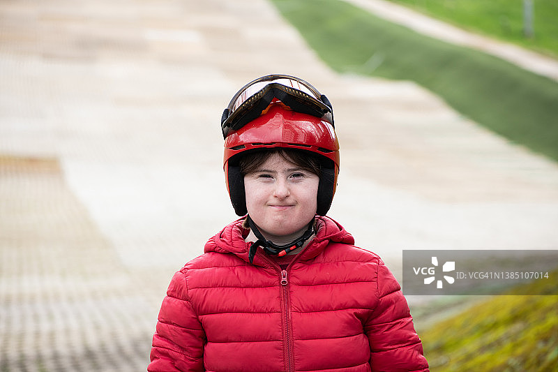 在旱雪滑雪道上的患有唐氏综合征的年轻女士肖像图片素材